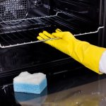 cleaning the oven with a sponge
