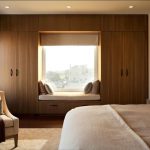 Kleiderschrank um das Fenster mit Sofa