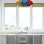 table le long de la fenêtre dans la pépinière avec un lustre