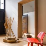 miroir dans le couloir avec une chaise en rouge