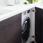 machine à laver dans la cuisine avec étagère